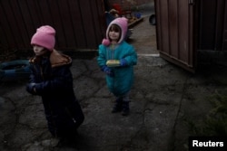 3-летняя Александра и 4-летняя Кристина в Бахмуте. 4 января 2023 года. Фото: Reuters