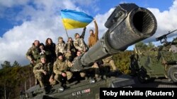 Украинские военные позируют на танке Challenger 2 на военной базе Bovington Camp в Великобритании